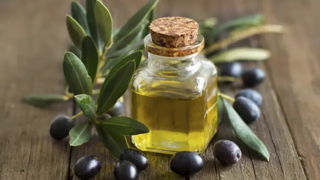 Huile d'olive et olives fraîches sur fond de bois rustique