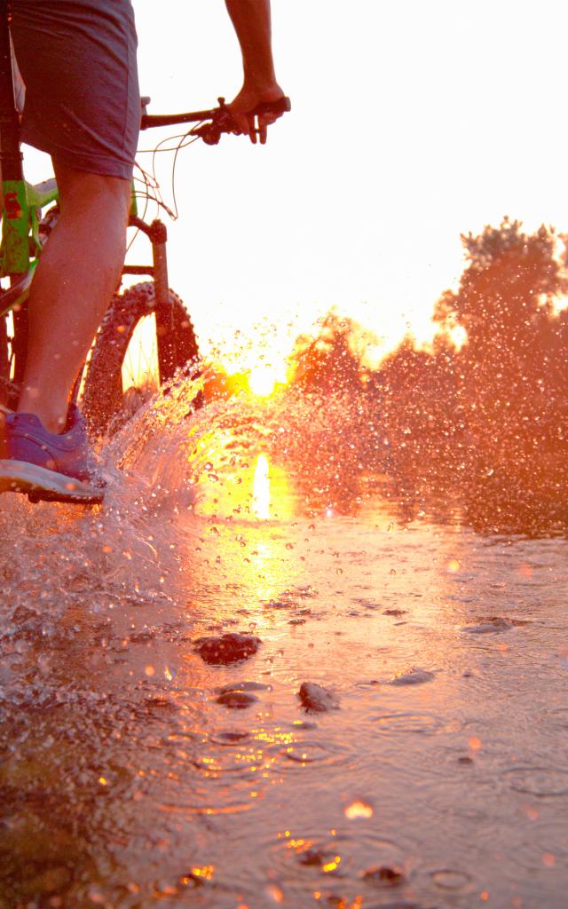 Sportif roulant à vélo dans un cours d'eau peu profond
