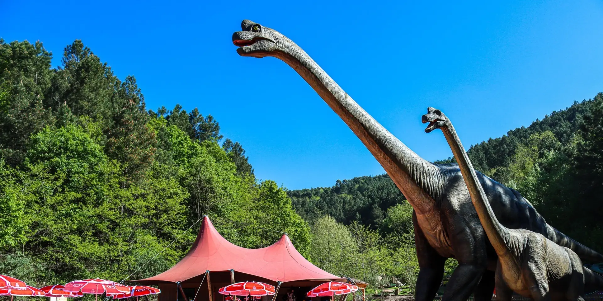 Deux dinosaures géants devant un paysage cévenol